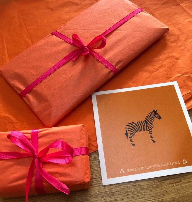 Wrapped gifts in orange tissue with pink ribbon